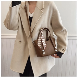 Detail of brown lychee texture bag with houndstooth silk scarf and silver hardware