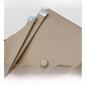 Detail of lychee pattern leather bucket bag with silk scarf handle and silver accents
