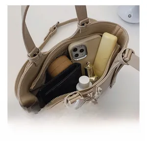 Internal view of minimalist beige handbag showing spacious storage with silk scarf detail