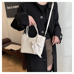 Detail of off-white lychee texture bucket bag with silk scarf and thin strap
