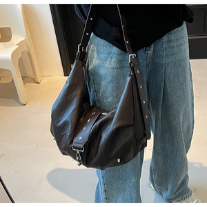 Detail of soft brown leather hobo bag with star studs and vintage buckle strap
