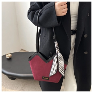 Detail of burgundy tote bag with V-shaped opening, fashion label and geometric scarf