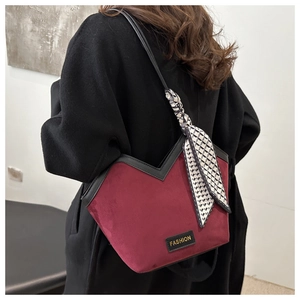Detail of burgundy matte tote with a V-shaped opening and checkered scarf accessory