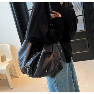 Detail of hobo bag with star studs, adjustable wide strap and textured leather finish