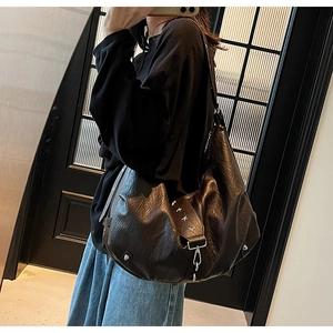 Detail of dark brown faux leather tote with vintage star rivets and metallic hooks