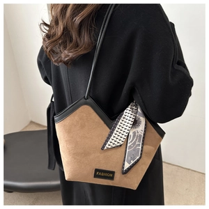 Detail of camel frosted tote bag featuring a V-cut edge and decorative silk scarf accessory