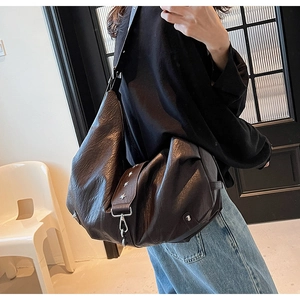 Detail of soft leather hobo bag featuring vintage star rivets and wide shoulder strap