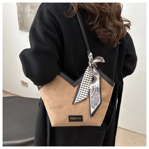 Close-up of brown suede tote bag with V-shaped opening and decorative printed scarf