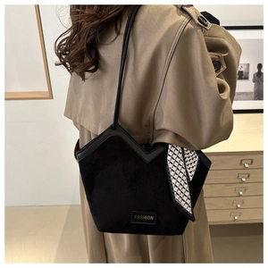 Detail of suede shoulder bag featuring a V-shaped cut and decorative silk scarf