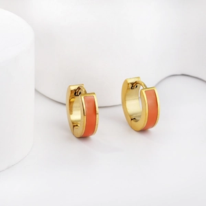 Golden stainless steel huggie earrings with vibrant orange enamel inlay in a modern C-shape