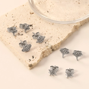 Set of four silver stud earrings with celestial and floral designs with white rhinestones