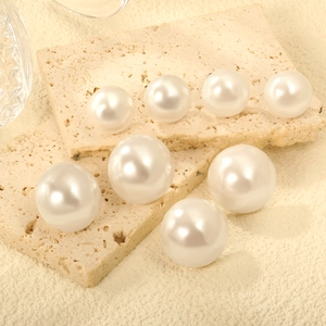 Élégant ensemble de sept boucles d'oreilles perles blanches sur un support en pierre