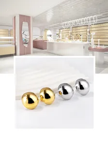 Macro view of minimalist semi-round stainless steel stud earrings in gold and silver