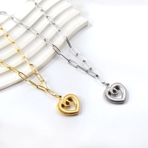 Close-up of heart pendants on paperclip chains in gold and silver stainless steel