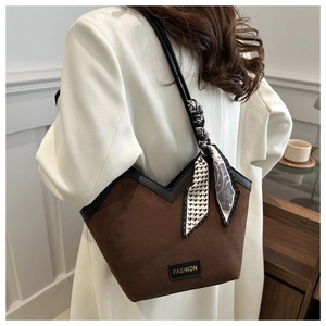 Detail of vintage brown suede tote bag with black leather trim and decorative silk scarf