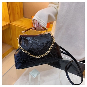 Detailliertes Lotus- und Koi-Relief auf schwarzer Abendtasche aus Prägeleder