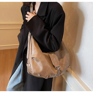 Detail of vintage brown tote bag with star studs and silver buckles on model