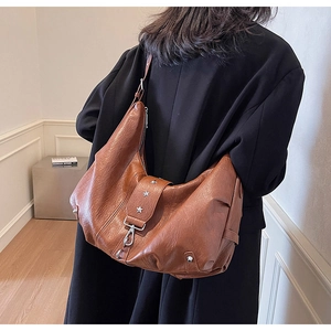 Brown soft leather hobo bag featuring silver star rivets and wide buckle strap design