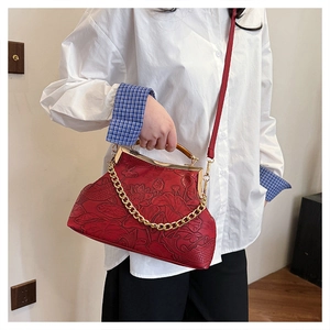 Detailansicht der roten Vintage-Handtasche mit Lotus-Prägung und goldenem Bügelverschluss