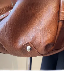 Detailed macro view of vintage brown lychee grain leather with silver stud accents