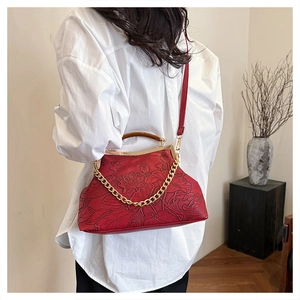 Detail der roten Ledertasche mit geprägtem Lotusmuster und Vintage-Kettenträgern
