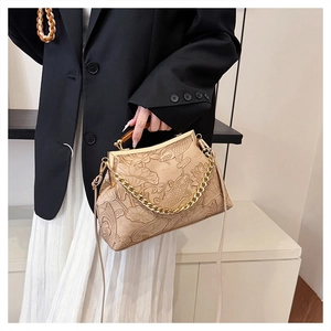 Detailansicht der Lotos- und Koi-Reliefs auf der beigen Vintage-Lederhandtasche