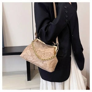 Detail der Vintage-Lotus- und Karpfenprägung auf beiger Abendtasche mit goldener Kette