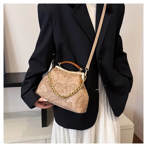 Detail der beige Retro-Clutch mit geprägten Lotus- und Koi-Mustern auf der Textur