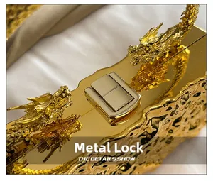 Macro di una clutch dorata con manico a forma di drago e chiusura metallica di lusso