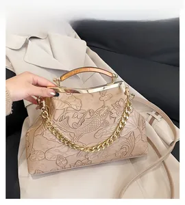 Detail der beige Retro-Handtasche mit Koi-Karpfen-Prägung, Lotusmuster und Holzgriff-Akzenten