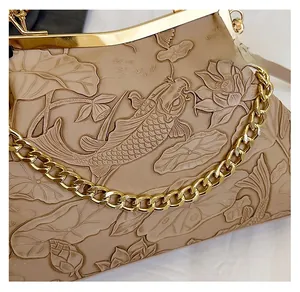 Detail der eleganten Lotus- und Karpfen-Prägung auf der beigen Retro-Abendtasche