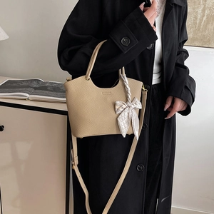 Chic beige lychee grain bucket bag with silk scarf detail and crossbody strap