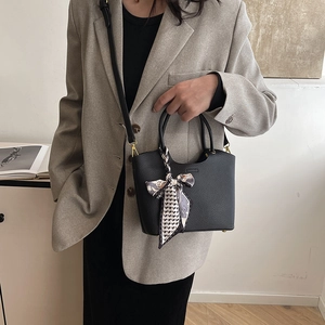 Black pebbled leather crescent bucket bag with patterned scarf detail and top handles