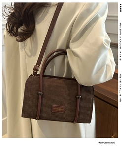 Detail of vintage brown corduroy shoulder bag with leather straps and metal buckles
