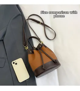 Vue détaillée du sac seau bicolore avec cordon et comparaison de taille avec smartphone