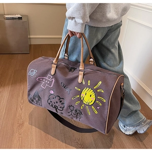 Brown canvas travel bag with colorful hand-drawn graffiti and leather handles