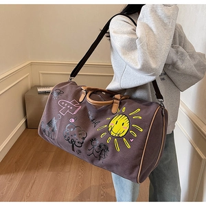 Detail of coffee purple travel bag with colorful hand-drawn graffiti and leather handles