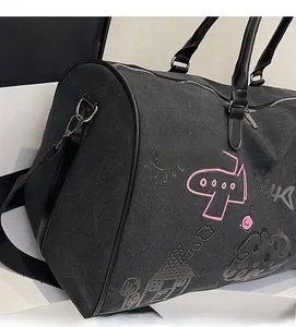Close-up of black travel bag with pink cartoon doodles showing sturdy canvas texture