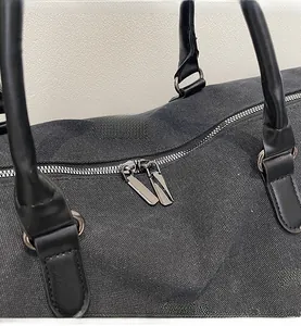 Close-up of smooth dual metal zippers on high-quality gray canvas travel bag