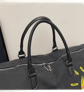 Macro shot of durable handles and smooth metal dual zippers on black canvas travel bag