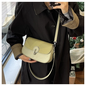 Detailed view of light green crossbody bag featuring straw weave and leather texture
