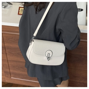 Detail of white semi-circular crossbody bag with textured stitching and silver clasp