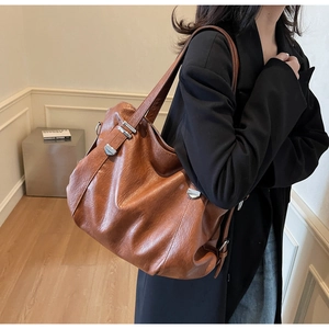 Detail view of large brown PU leather tote bag with silver square buckle for office commute