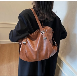 Detail view of a vintage brown leather tote bag showing soft texture and spacious capacity