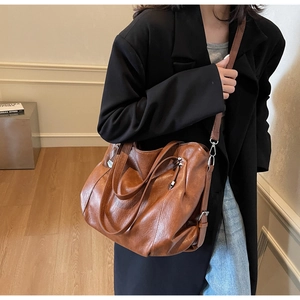 Detailed view of a brown vintage tote bag with high-quality leather texture and strap