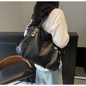 Close-up of black leather tote bag with silver hardware on model for daily commute