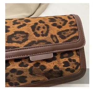 Close-up of leopard print texture and dark brown leather trim with fine stitching details