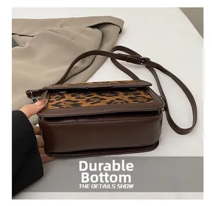 Detail view of the wear-resistant wide base and sturdy structure of this leopard print bag