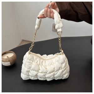 Close-up of white quilted puffer cloud bag with gold chain and padded shoulder strap