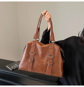 Vue macro du sac vintage marron montrant le cuir grainé et les anneaux en D argentés